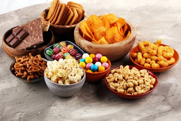 Salty snacks. Pretzels, chips, crackers in wooden bowls. — Stock Photo, Image