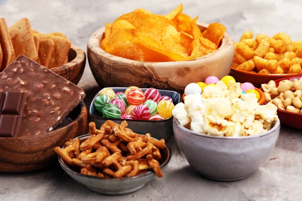 Snacks salados. Pretzels, papas fritas, galletas en cuencos de madera . — Foto de Stock