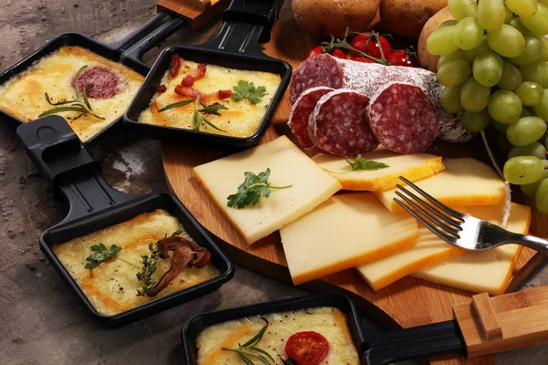Delicioso queijo raclette tradicional suíço derretido em fervura em cubos — Fotografia de Stock