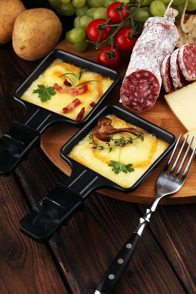 Delicioso queijo raclette tradicional suíço derretido em fervura em cubos — Fotografia de Stock