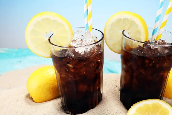 Softdrink com cubos de gelo, limão e palha em vidro. — Fotografia de Stock