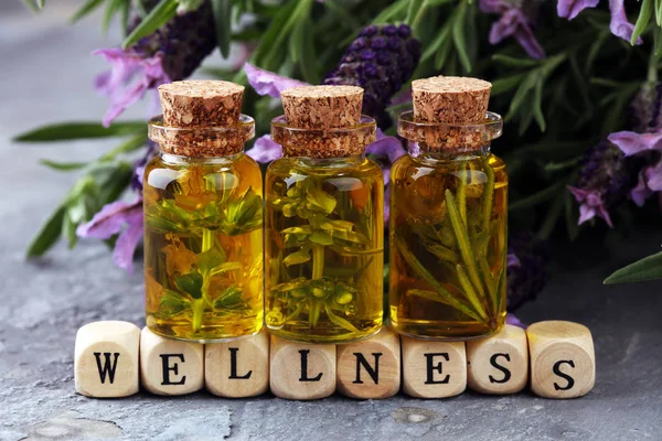 Taze çiçekler bir cam şişe bir arka plan üzerinde lavanta yağı.