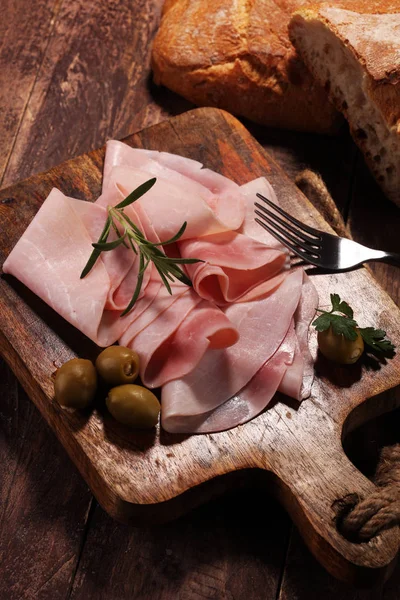 Jamón en rodajas sobre fondo de madera. Prosciutto fresco. Jamón de cerdo slic —  Fotos de Stock