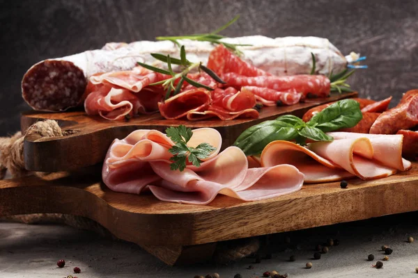 Bandeja de comida con delicioso salami, jamón, salchichas frescas y hierbas . —  Fotos de Stock
