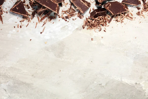 Темні шоколадні батончики на кам'яному столі і зламані шматки какао — стокове фото