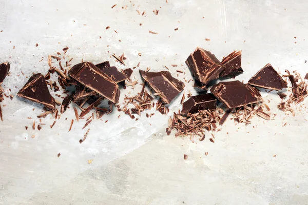 Donkere chocolade repen op stenen tafel en gebroken stukken van cacao — Stockfoto