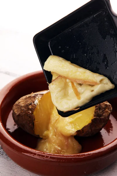 Queso raclette derretimiento sobre patata servido en sartén individual . — Foto de Stock