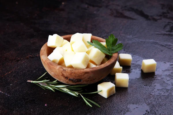 Cubos de queijo em tigela de madeira com salsa. pedaços de queijo na mesa — Fotografia de Stock