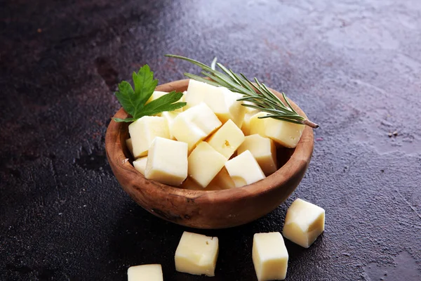 Cubos de queijo em tigela de madeira com salsa. pedaços de queijo na mesa — Fotografia de Stock