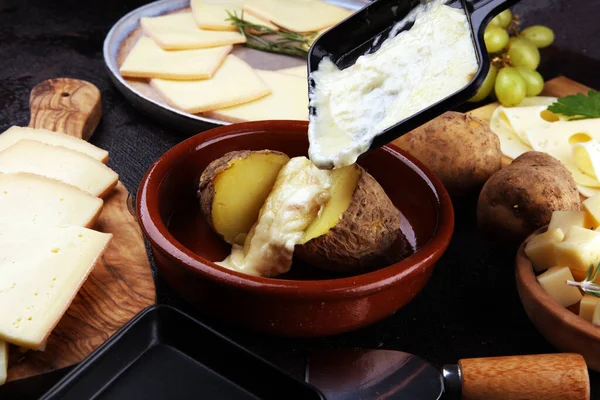 Formaggio raclette che si scioglie sulla patata servito in padelle individuali . — Foto Stock