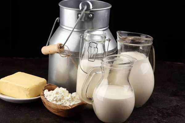 Különböző egészséges tejtermékek rusztikus alapon tejjel — Stock Fotó
