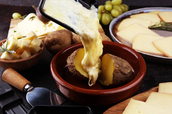 Raclette cheese melted served in individual raclette skillets — Stock Photo, Image