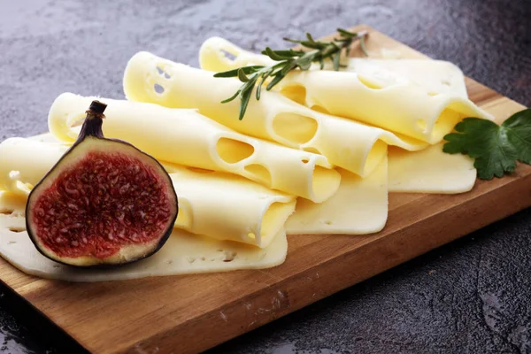 Plátky sýra na dřevěném podnosu s petrželí. sýr gauda — Stock fotografie