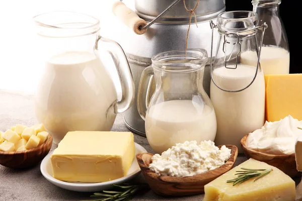 Verschiedene gesunde Milchprodukte auf rustikalem Hintergrund mit Milch — Stockfoto