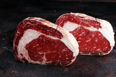 Çiğ et, pirzola, baharat ve et çatalı.