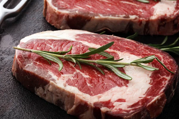 Carne fresca cruda Ribeye Filete, condimento y tenedor de carne en rústico b — Foto de Stock