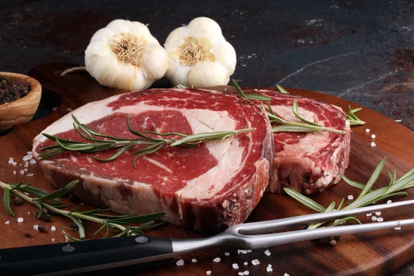 Obearbetat färskt kött Ribeye Biff, krydda och köttgaffel på rustik b — Stockfoto