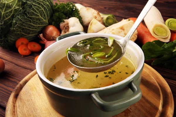 Caldo con zanahorias, cebollas varias verduras frescas en una olla - c — Foto de Stock