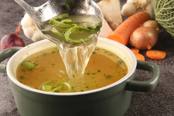 Brodo con carote, cipolle varie verdure fresche in una pentola - c — Foto Stock