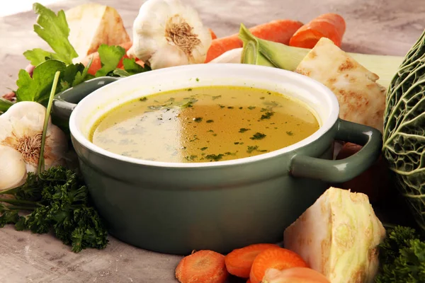 Caldo com cenouras, cebolas várias verduras frescas em um pote - c — Fotografia de Stock