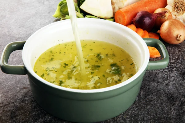 Bouillon aux carottes, oignons divers légumes frais dans une casserole - c — Photo