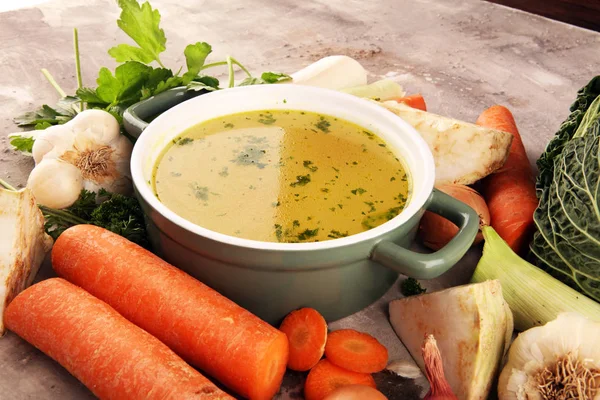 Caldo com cenouras, cebolas várias verduras frescas em um pote - c — Fotografia de Stock