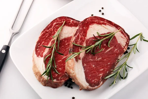 Raw fresh meat Ribeye Steak, seasoning and meat fork on rustic b — Stock Photo, Image