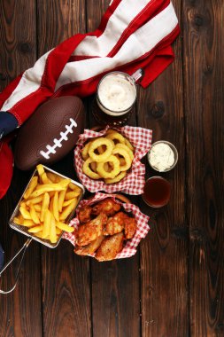 tavuk kanatları, patates kızartması ve bir masada futbol için soğan halkaları. Gr