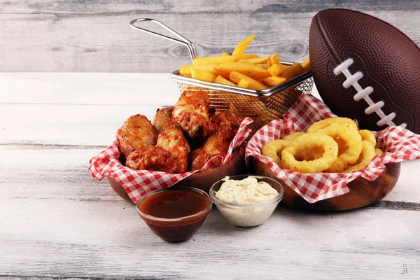 Chicken wings, fries and onion rings for football on a table. Gr — Stock Photo, Image