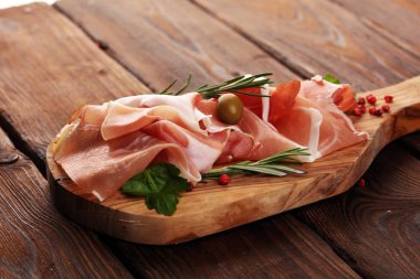 Italian prosciutto crudo or jamon with rosemary. Raw ham with sp clipart