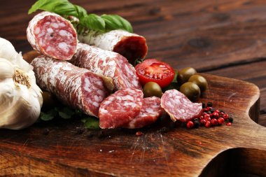 thinly sliced salami on a wooden texture on the background. clipart