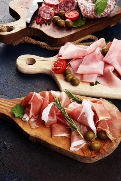 Bandeja de comida con delicioso salami, trozos de jamón crudo en rodajas — Foto de Stock