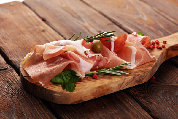 Italian prosciutto crudo or jamon with rosemary. Raw ham with sp