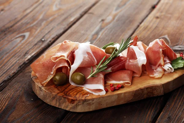 Włoskie crudo prosciutto lub jamon z rozmarynem. Surowa szynka z sp — Zdjęcie stockowe