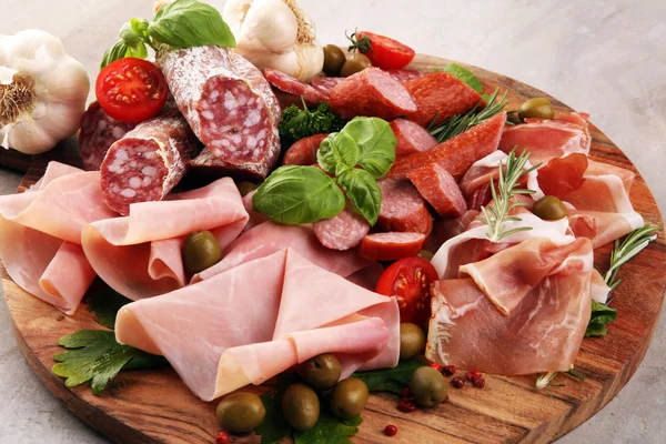 Bandeja de comida com delicioso salame, pedaços de presunto cru fatiado — Fotografia de Stock