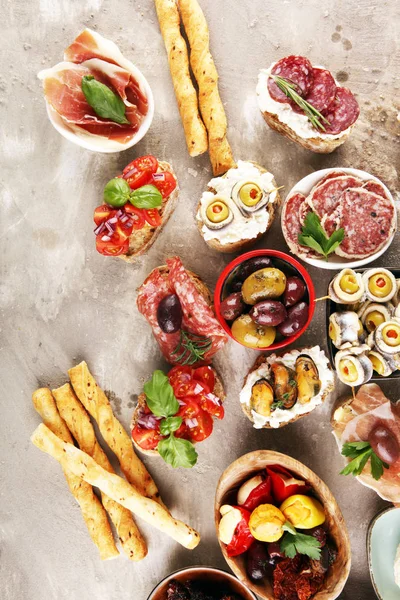 Appetizers table with italian antipasti snacks and wine in glass