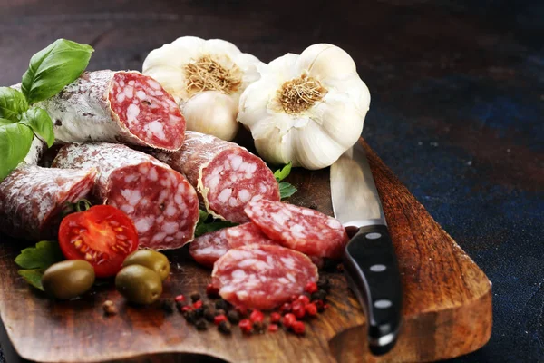 Thinly sliced salami on a wooden texture on the background. — Stock Photo, Image