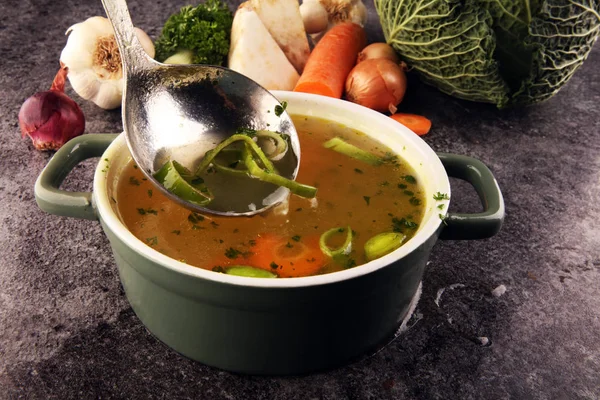 Broth with carrots, onions various fresh vegetables in a pot - c — Stock Photo, Image