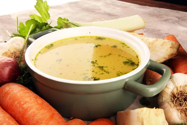 Caldo com cenouras, cebolas várias verduras frescas em um pote - c — Fotografia de Stock