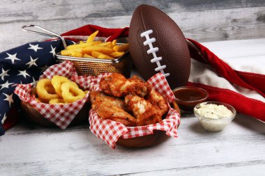 tavuk kanatları, patates kızartması ve bir masada futbol için soğan halkaları. Gr