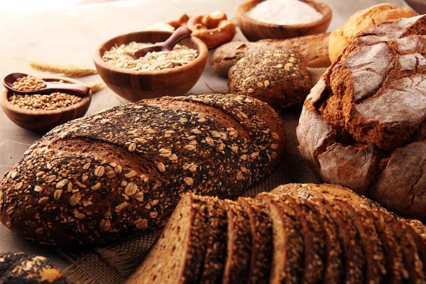 Sortiment von gebackenem Brot und Brötchen und geschnittenem Brot auf ta — Stockfoto