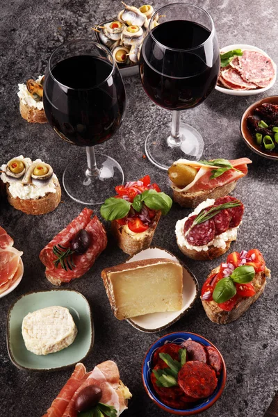 Předkrm stůl s italskými antipasti občerstvením a vínem ve skle — Stock fotografie