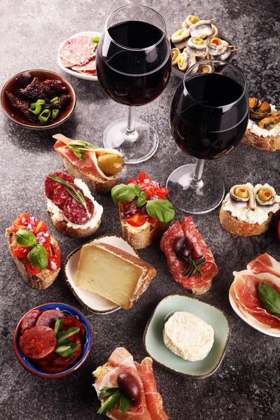 Appetizers table with italian antipasti snacks and wine in glass — Stock Photo, Image