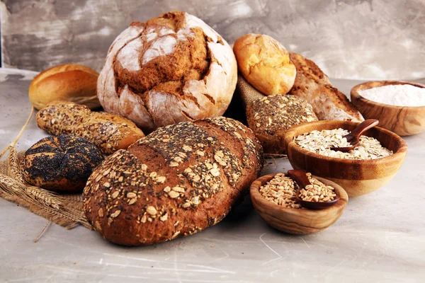 Sortiment av bakat bröd och bröd rullar och skärt bröd på ta — Stockfoto