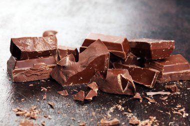 Koyu çikolata yığını, çikolata parçacıkları ve pudra.