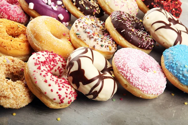 Разнообразные пончики с шоколадной глазурью, розовые глазурованные и посыпать — стоковое фото