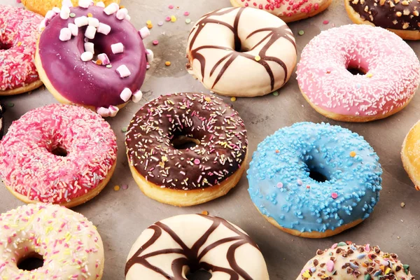 Разнообразные пончики с шоколадной глазурью, розовые глазурованные и посыпать — стоковое фото