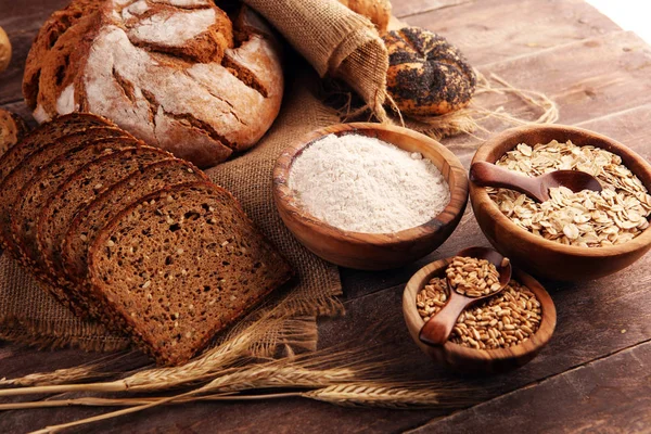 Assortimento di pane e panini al forno e pane tagliato su ta — Foto Stock
