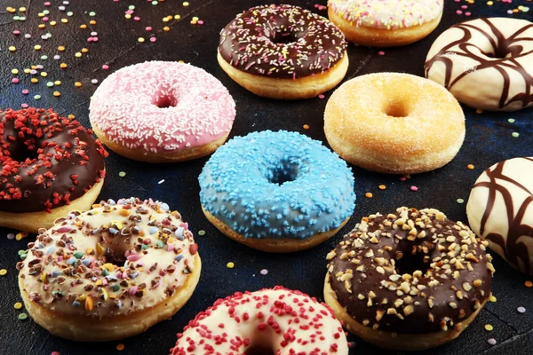 Donuts variados com chocolate fosco, vidros rosa e polvilhe — Fotografia de Stock
