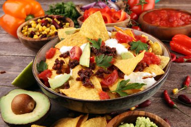 mexican nacho chips garnished with ground beef, guacamole, melte clipart